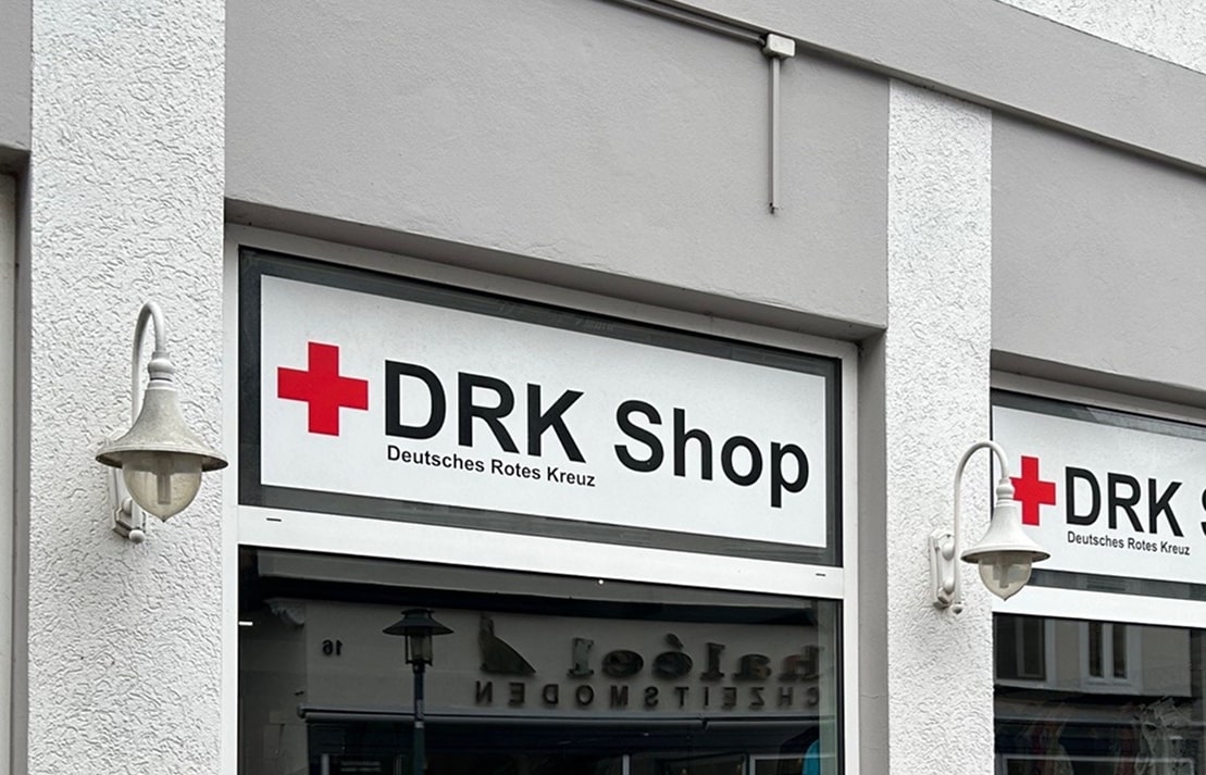 Außenansicht des DRK Shops in Stadthagen mit Kleiderständern vor dem Eingang.