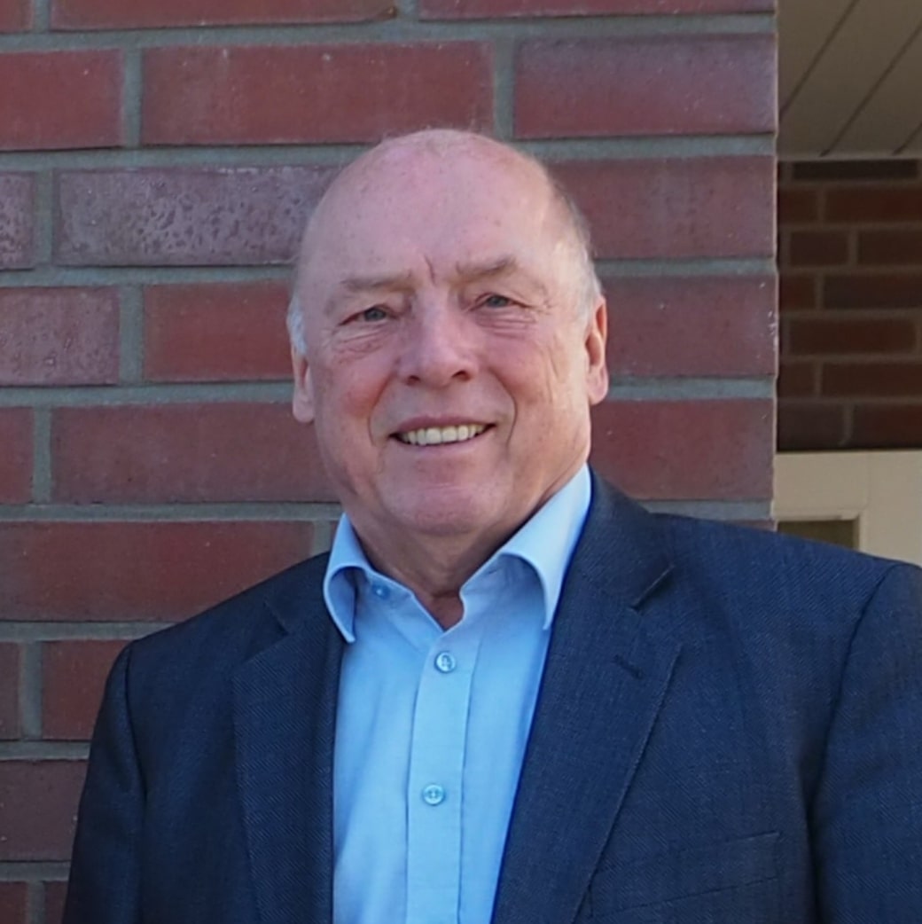 Porträt von Reiner Brombach, Präsident des DRK-Kreisverbands Schaumburg, vor roter Backsteinwand.